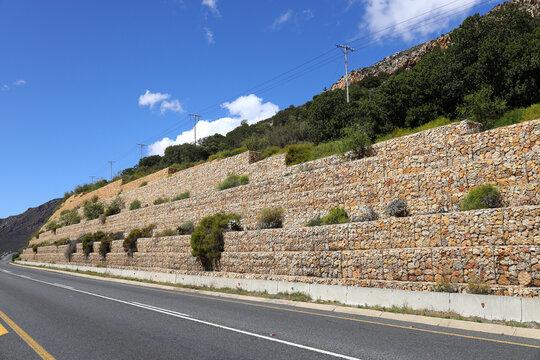 A gabion retaining wall next to a roadway  that runs through the farming community of De Doorns in the Western Cape Province in South Africa.