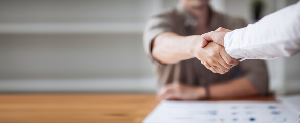 Close up of two businesspeople shaking hands after a deal contract is done. - obrazy, fototapety, plakaty