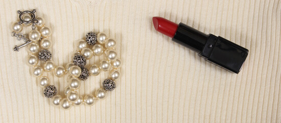 Pearls and Red Lipstick on Cream Colored Sweater Closeup