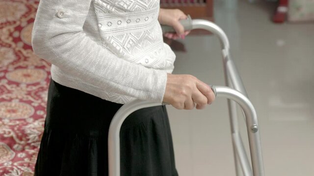 Senior woman holding on walker at home