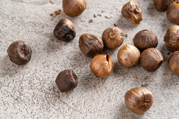 Fermented black garlic. The color is a result of the Maillard reaction or caramelization. Black garlic can help to regulate blood sugar levels. negative space. selective focus.