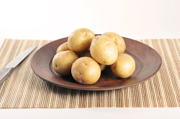 young potatoes in the peel on a clay plate