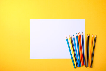 A clean white sheet and colored pencils for drawing on a yellow background with a place for copying and inscriptions.