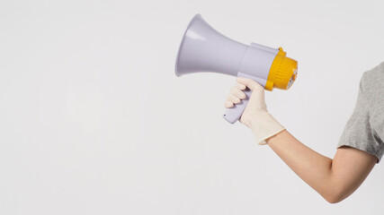 Hand is hold megaphone and wear medical glove on white background..