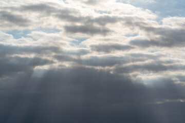 ray tuft (light tuft), sun rays fight through a gray cloud layer, cloud rays, twilight rays, concept of hope, religion and divinity