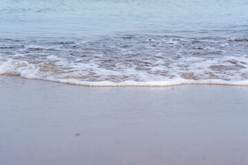 Foamy sea water washed up on the beach, small waves on the shore, Moody background wallpaper