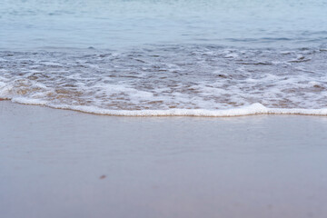 Foamy sea water washed up on the beach, small waves on the shore, Moody background wallpaper