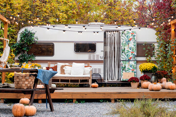 Autumn camping. The trailer is decorated with autumn flower, .pumpkins, decor. - obrazy, fototapety, plakaty