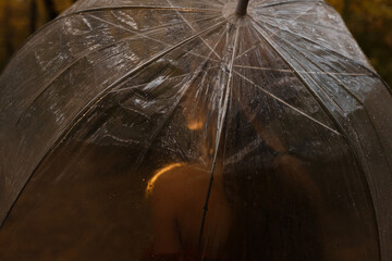 model with a transparent umbrella in autumn. dark photo