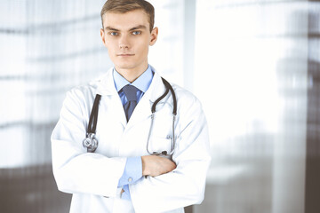 Doctor man, with a stethoscope, stands at his hospital office. Perfect medical service in clinic. Happy future in medicine and healthcare
