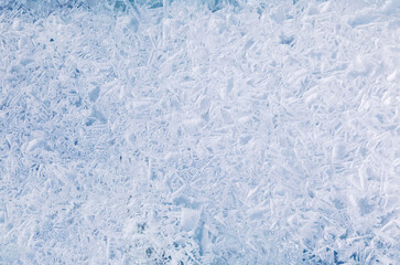 Fototapeta na wymiar Winter texture of natural blue sea ice. Abstract cold background. Frozen water backdrop. Blank for text. Close-up, flat lay, top view, mock up