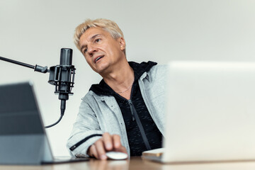 A journalist and a laptop. The radio host transmits good news. Speaks into the microphone. Live...
