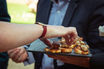 Le serveur présente des toasts de foie gras lors d'un réception de mariage