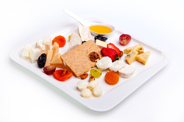 Cheese plate beautifully laid appetizer in a restaurant, Cheese, nuts and berries on a white background.