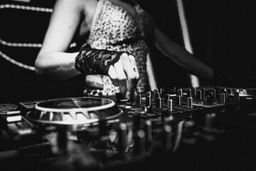 Female deejay playing hits in a party of electronic music.