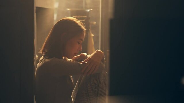 4K Loneliness Asian woman sitting on the floor with hugging herself. Beautiful female feeling depressed living alone in the dark and think of life problems. Mental health and social issue concept.
