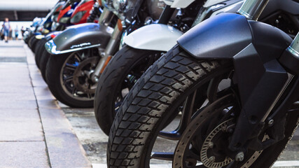Fototapeta na wymiar motorcycles parked on the motorcycles parking lot on the street. Closeup view of motorcycles front wheels