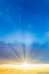 vertical Sky blue and orange light of the sun through the clouds in the sky