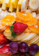 Berry mix dessert beautifully laid on a plate in a restaurant. A variety of berries and fruits are sliced on a white plate. Serving dishes.