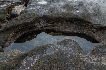 Puddle of water with rocks in it at the beach in Bali Indonesia