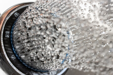 The water drops running from the shower head, close up view.