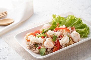 instant noodle spicy salad.Thai hot and sour noodle salad with squid shrimp and minced pork that is very flavorful and addictive