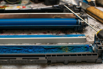 a view of colored toner in the hopper of the blue laser printer cartridge, which lies against the...
