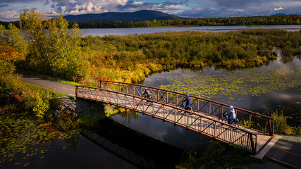 Group bike ride on the Granbyenne bike path in autumn on the bridge across Lake Boivin in Granby, Quebec, Canada.