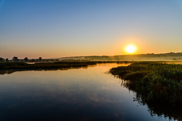 Fototapeta na wymiar Fog above the water surface. Sunrise at river