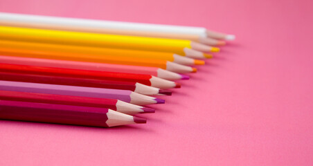Colored pencils on a pink background