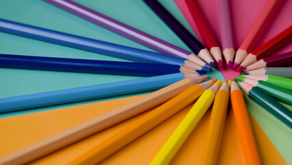 Naklejka premium Colored pencils on a multicolored background