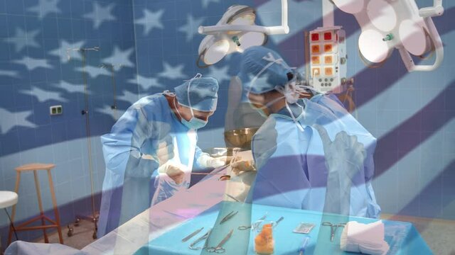 Animation of flag of united states of america waving over surgeons in operating theatre