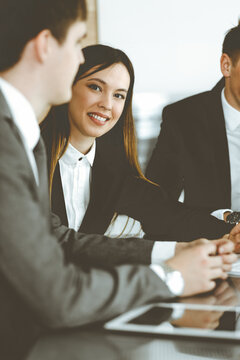 Businessman and woman with colleague sitting and working at the desk. Business people discussing questions at meeting in sunny office