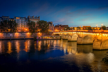 Paris, France - July 8, 2021: Pont Neuf bridge and Cite island over Seine river at night in Paris
