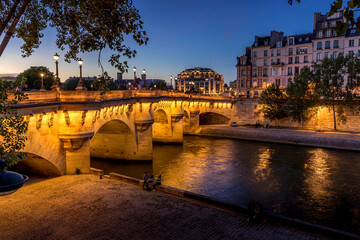 Paris, France - July 8, 2021: Pont Neuf bridge and Cite island over Seine river at night in Paris - obrazy, fototapety, plakaty