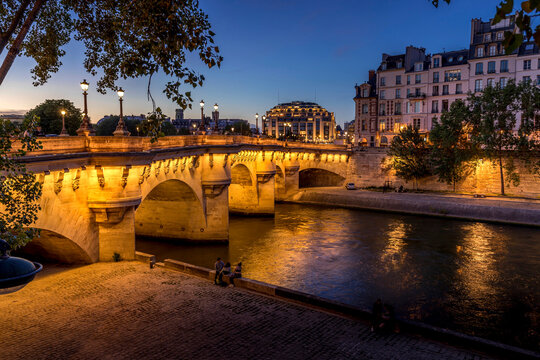 Paris, France - July 8, 2021: Pont Neuf bridge and Cite island over Seine river at night in Paris