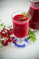 freshly squeezed thick natural juice with pulp from ripe red viburnum in a decanter