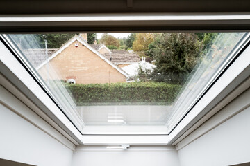 Abstract view of a newly installed skylight window in a loft conversion. Distant bungalows can be...