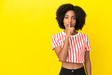 Young African American woman isolated on yellow background showing a sign of silence gesture...