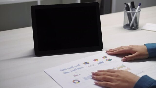Online meeting. Business analyzing. Video call. Remote work. Accounter woman hands checking data graphs at digital tablet with copy space empty mockup screen at home office .