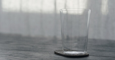 empty tumbler glass on black oak table