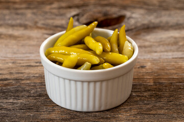 Green chilli pepper pickled on wooden background