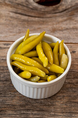 Green chilli pepper pickled on wooden background