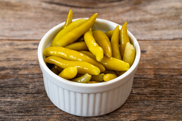 Green chilli pepper pickled on wooden background