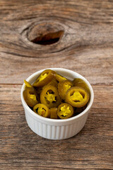 pickled sliced green jalapeno peppers in white bowl