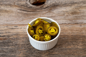 pickled sliced green jalapeno peppers in white bowl