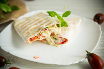 baked pita roll with filling in a plate on the table