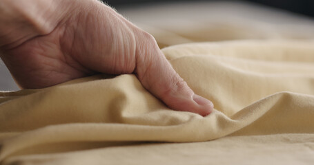 man touching yellow cotton clothes closeup