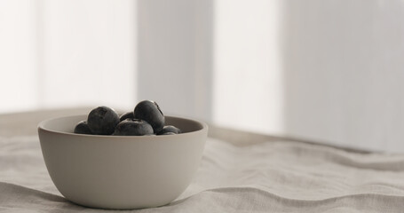 fresh blueberries in blue bowl on linen cloth