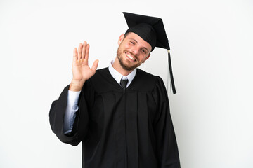 Young university Brazilian graduate isolated on white background saluting with hand with happy expression